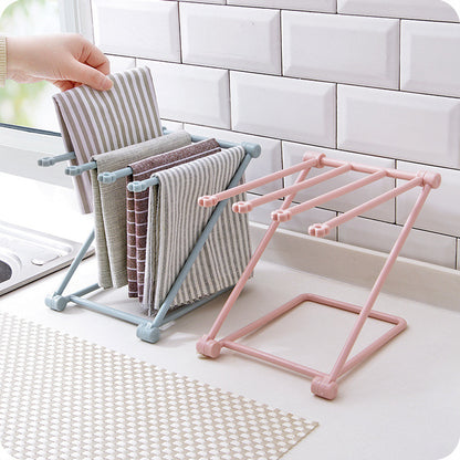 Foldable dishcloth shelf holding wet kitchen towels and sponge by a sink